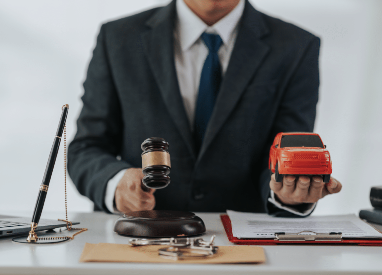 person hold auction hammer in one hand and a toy car in another hand