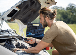 person working on car engine bay
